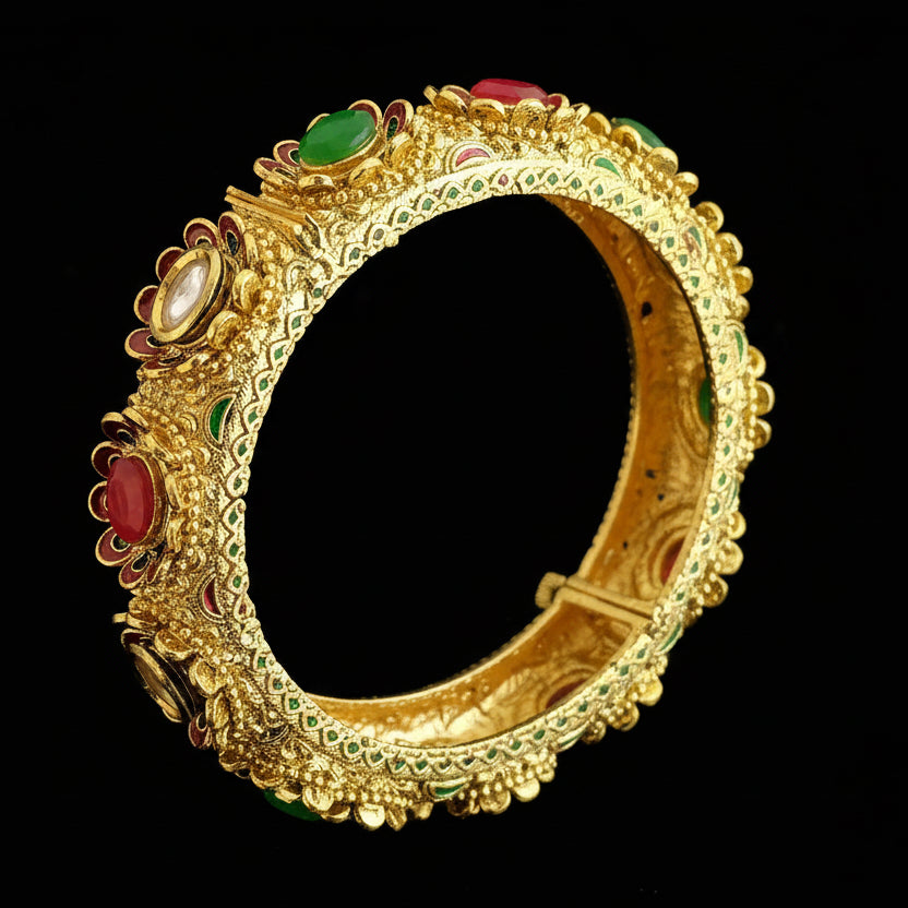 Gold bracelet with gemstones on a gray background, featuring the brand 'SAHELI'.