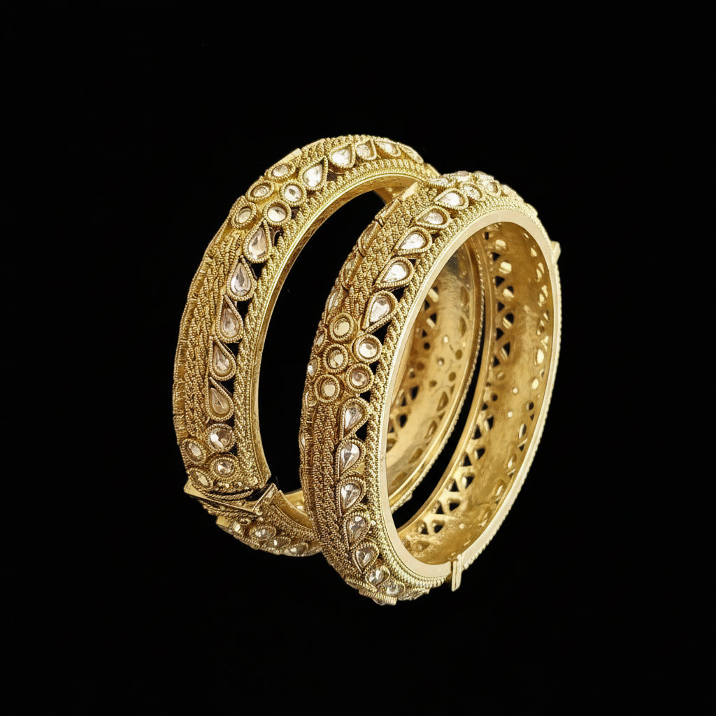 Gold earrings with intricate designs on a gray background, featuring the brand 'Saheeli'.