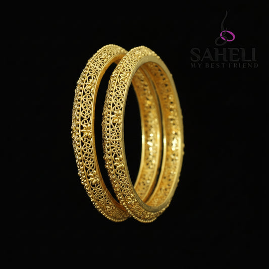 Gold bangles on a dark background with 'Saheli' branding.