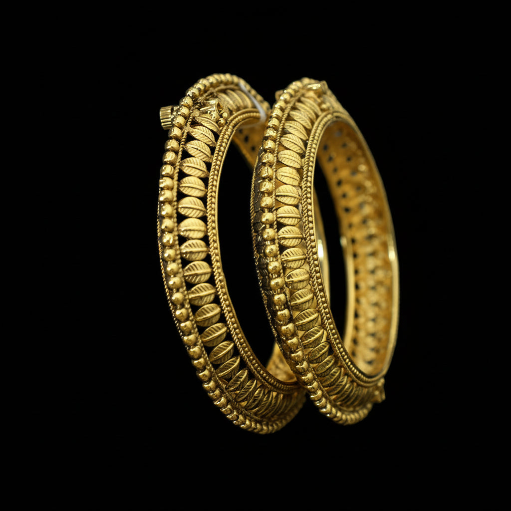 Pair of gold bangles on a stand with 'Saheli' branding in the background.