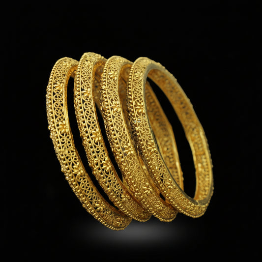 Set of gold bangles on a black stand with 'Saheli' branding.