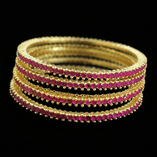 Set of gold and red bangles on a mannequin with 'SAHELI' branding.