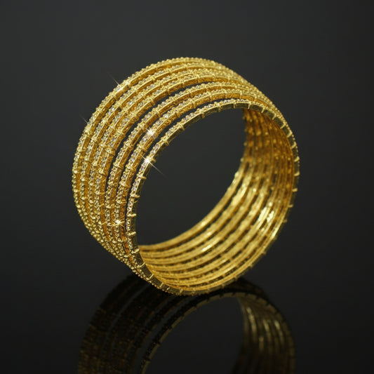 Gold bangles on a black stand with 'SAHELLI' branding in the corner.