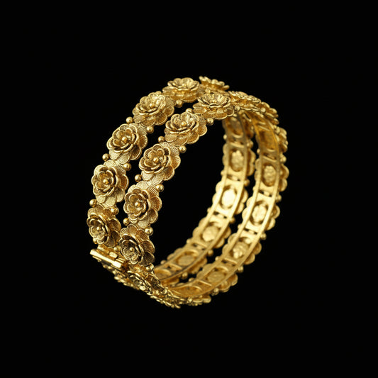 Gold bracelet with floral design on a gray cushion, branded 'Saheli'.