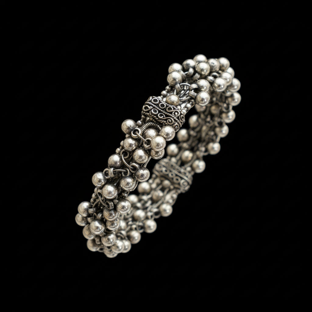 Silver beaded bracelet on a gray stone surface with 'SAHELI' branding.
