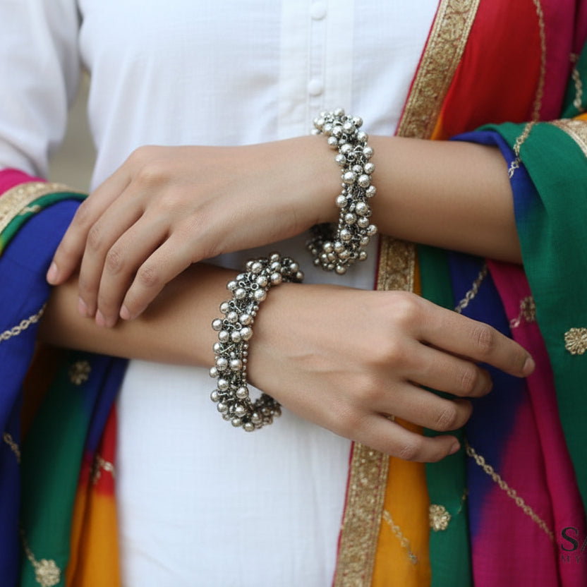 Silver beaded bracelet on a gray surface with 'SAHELI' branding.