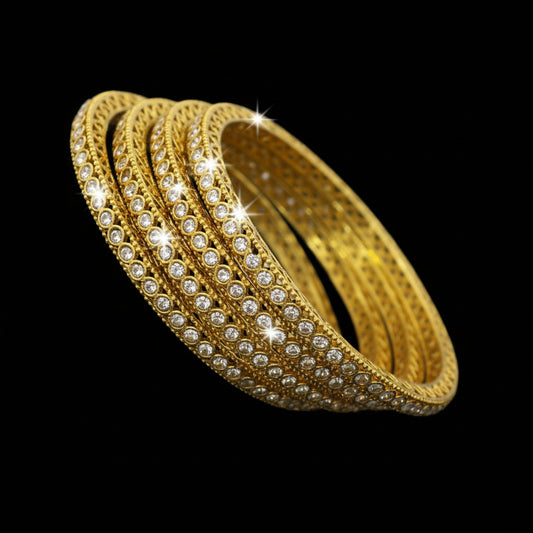 Gold bracelet with red stones on a reflective surface, branded 'Saheli'.
