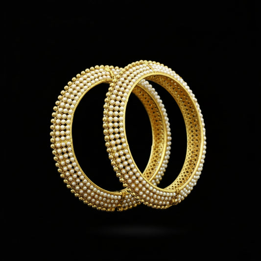 Gold bangles on a black stand with 'SAHELI' branding.
