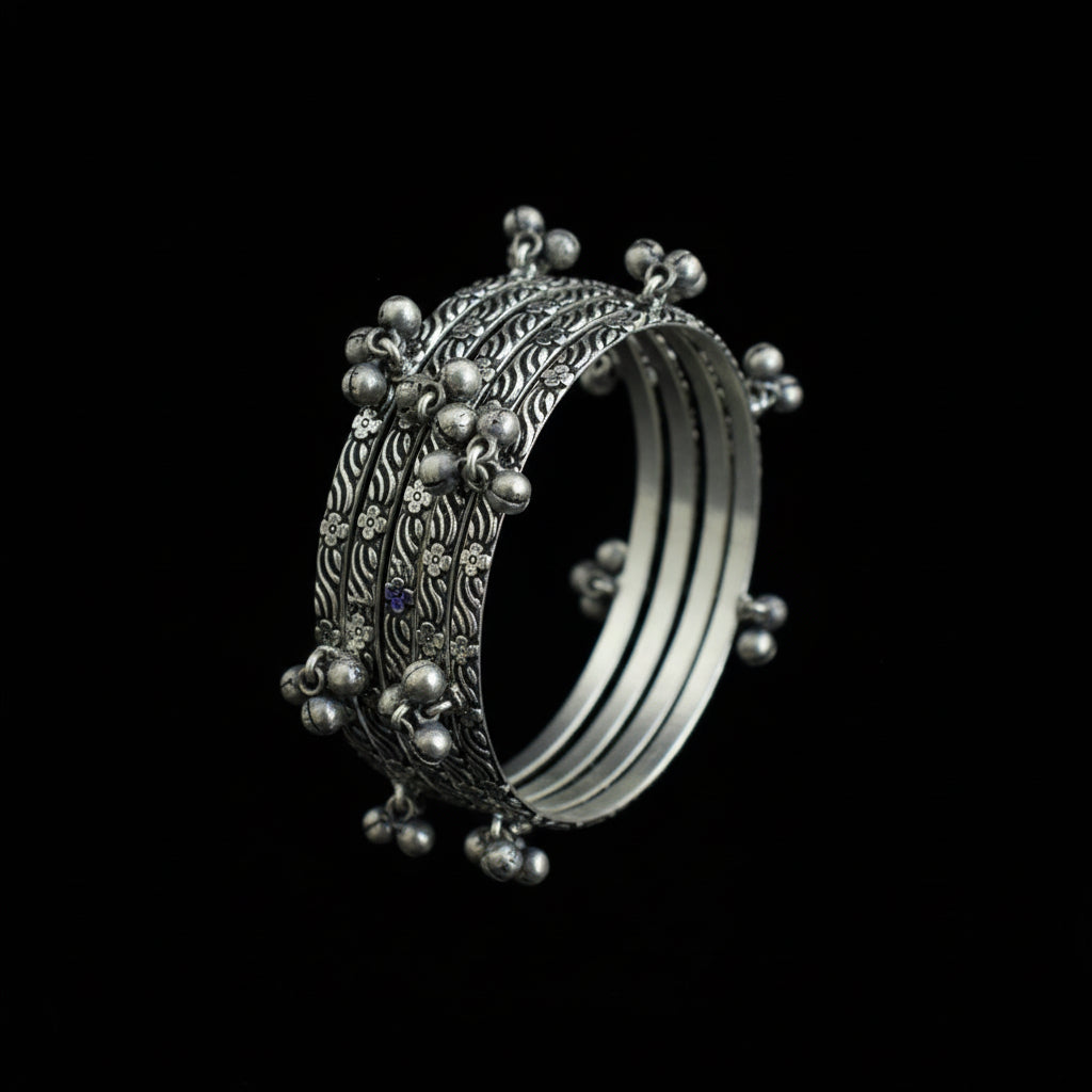 Set of silver bangles on a gray stand with 'SAHELI' branding.