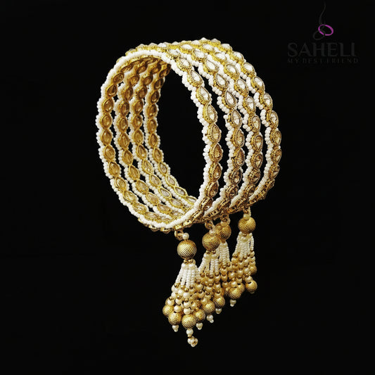 Gold and white jewelry set on a black stand with 'SAHELI' branding.