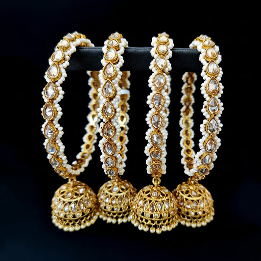 Gold and pearl earrings on a black background with 'Saheli' branding.