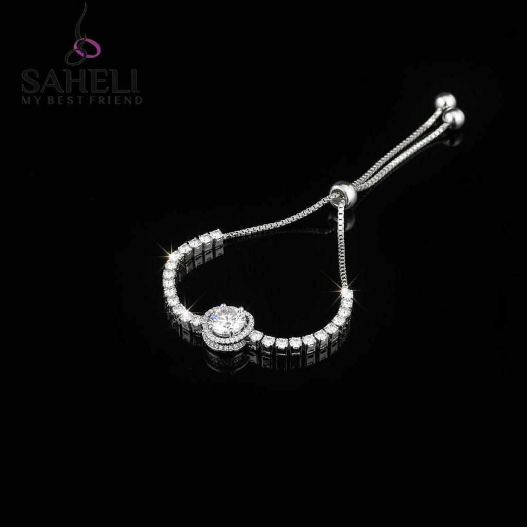 Silver bracelet with heart-shaped clasp on a dark background, featuring the brand 'SAHELI'.