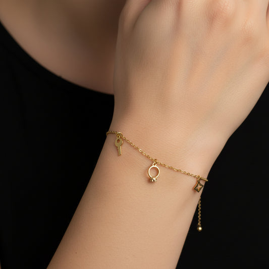 Gold necklace with three charms on a dark background