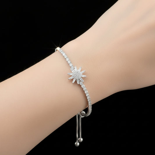 Silver bracelet with star-shaped clasp on a dark background, branded 'SAHELI'.