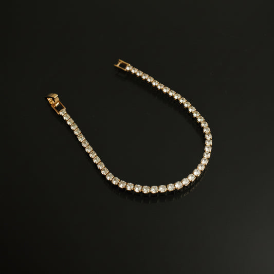 Gold bracelet with clear stones on a black background