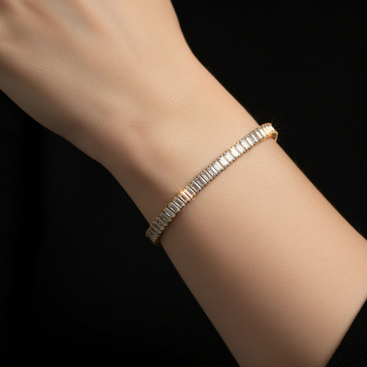 Gold bracelet with diamond accents on a dark reflective surface