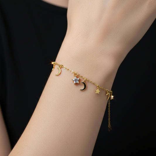 Gold necklace with star and moon charms on a black background