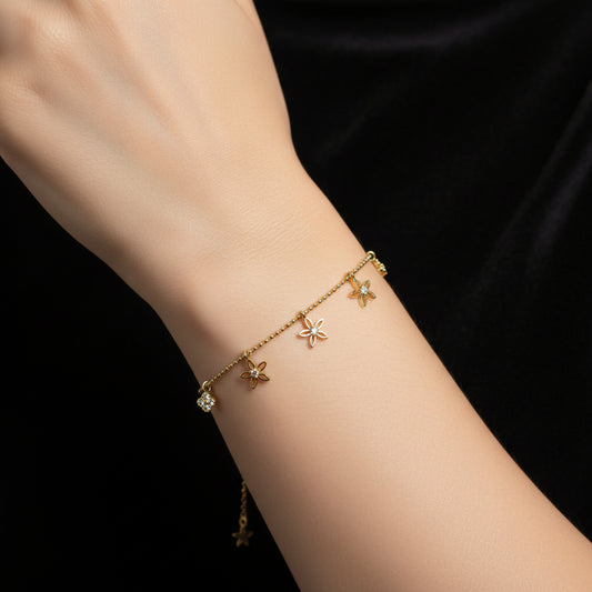 Gold necklace with floral pendants on a dark background
