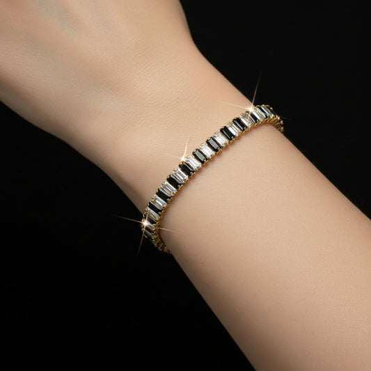 Gold bracelet with clear stones on a black background