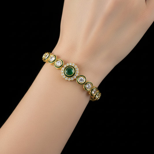 Gold bracelet with green gemstone on a dark background, branded 'Saheli'.