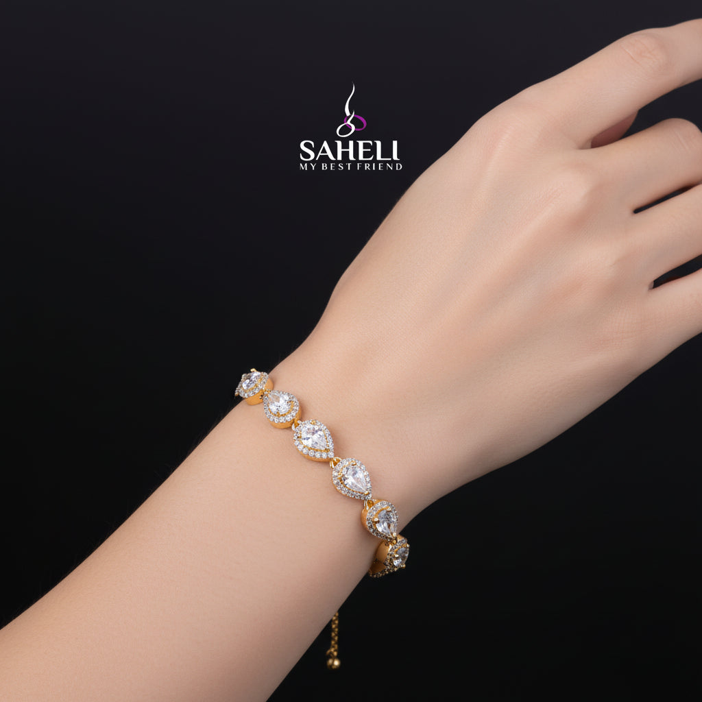 Gold bracelet with clear stones on a black background, featuring the brand 'Saheli'.