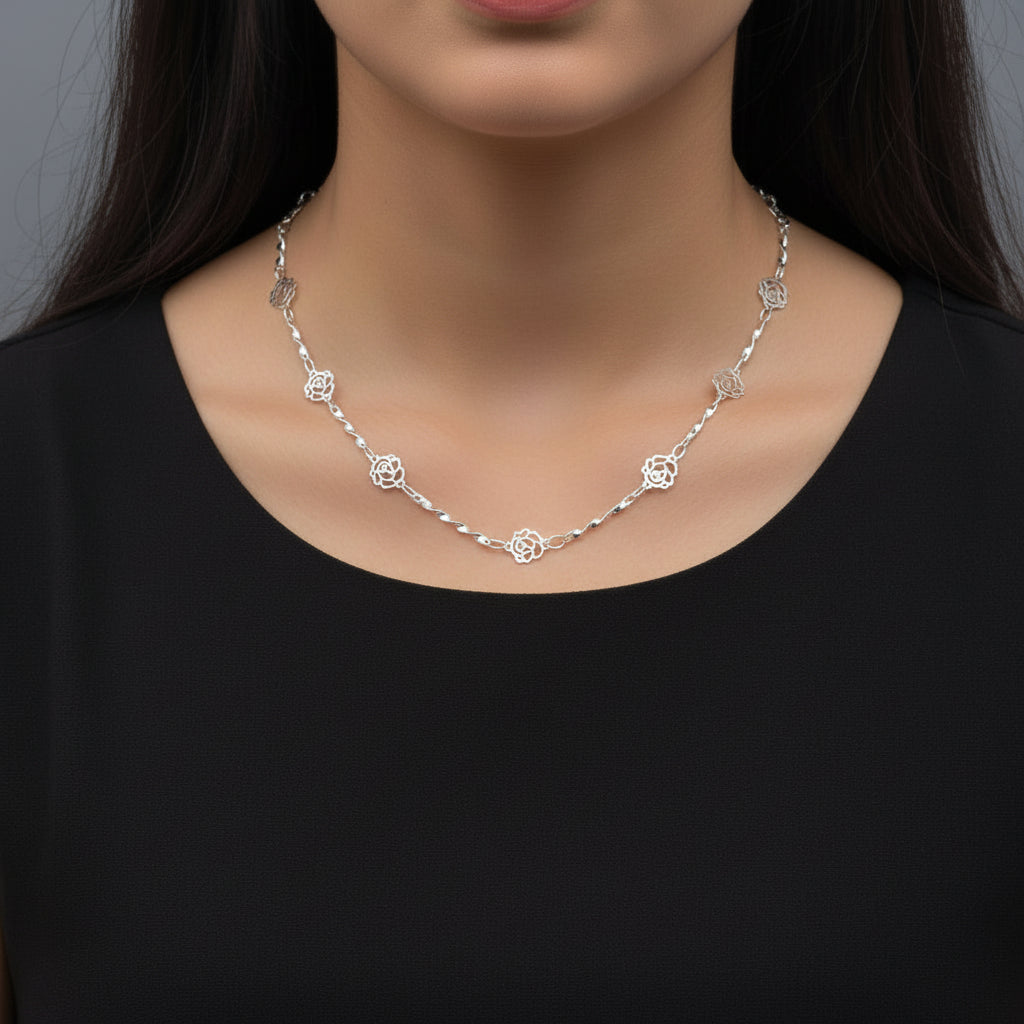 Silver necklace on a black mannequin with 'SAHELI' branding.