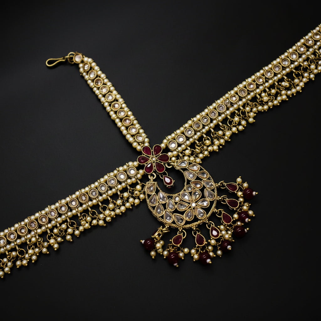 Ornate necklace with pearls and red gemstones on a dark background