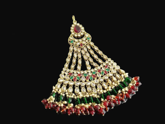 Ornate gold, green, and red jewelry piece with 'SAHELI' branding on a gray background