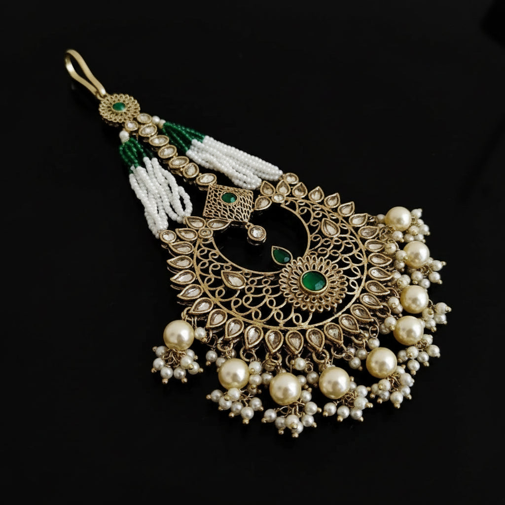 Decorative pendant with pearls and green stones on a black background