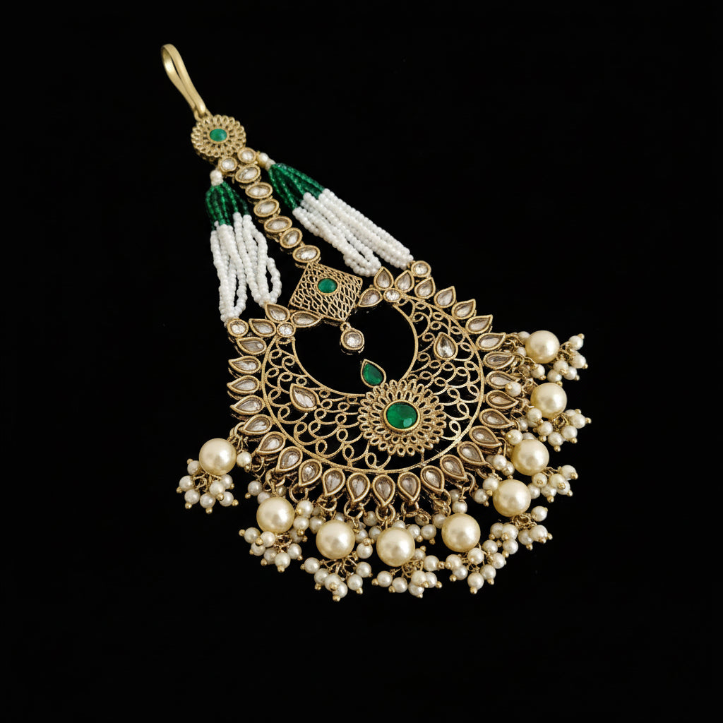 Decorative pendant with pearls and green stones on a black background