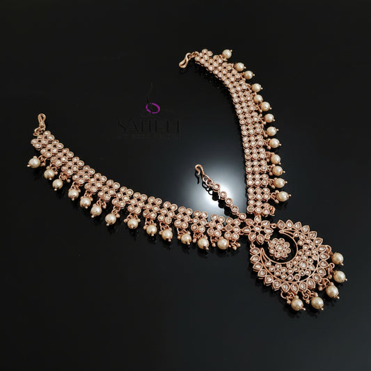 Delicate gold necklace with pearls on a dark background, featuring the brand 'Saheli'.