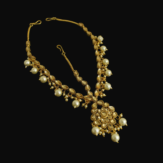 Gold necklace with pearl-like beads on a black background