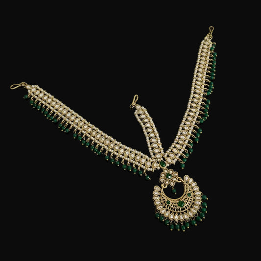 Ornate necklace with green gemstones on a dark background