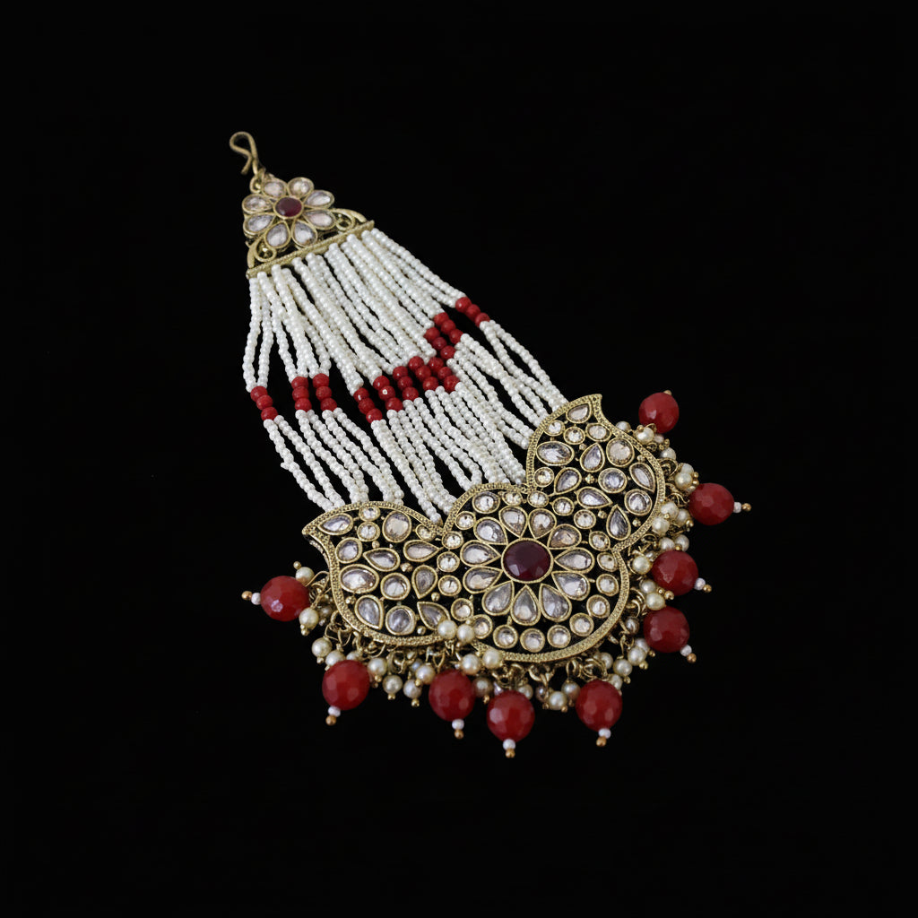 Decorative necklace with red beads and gold accents on a dark background