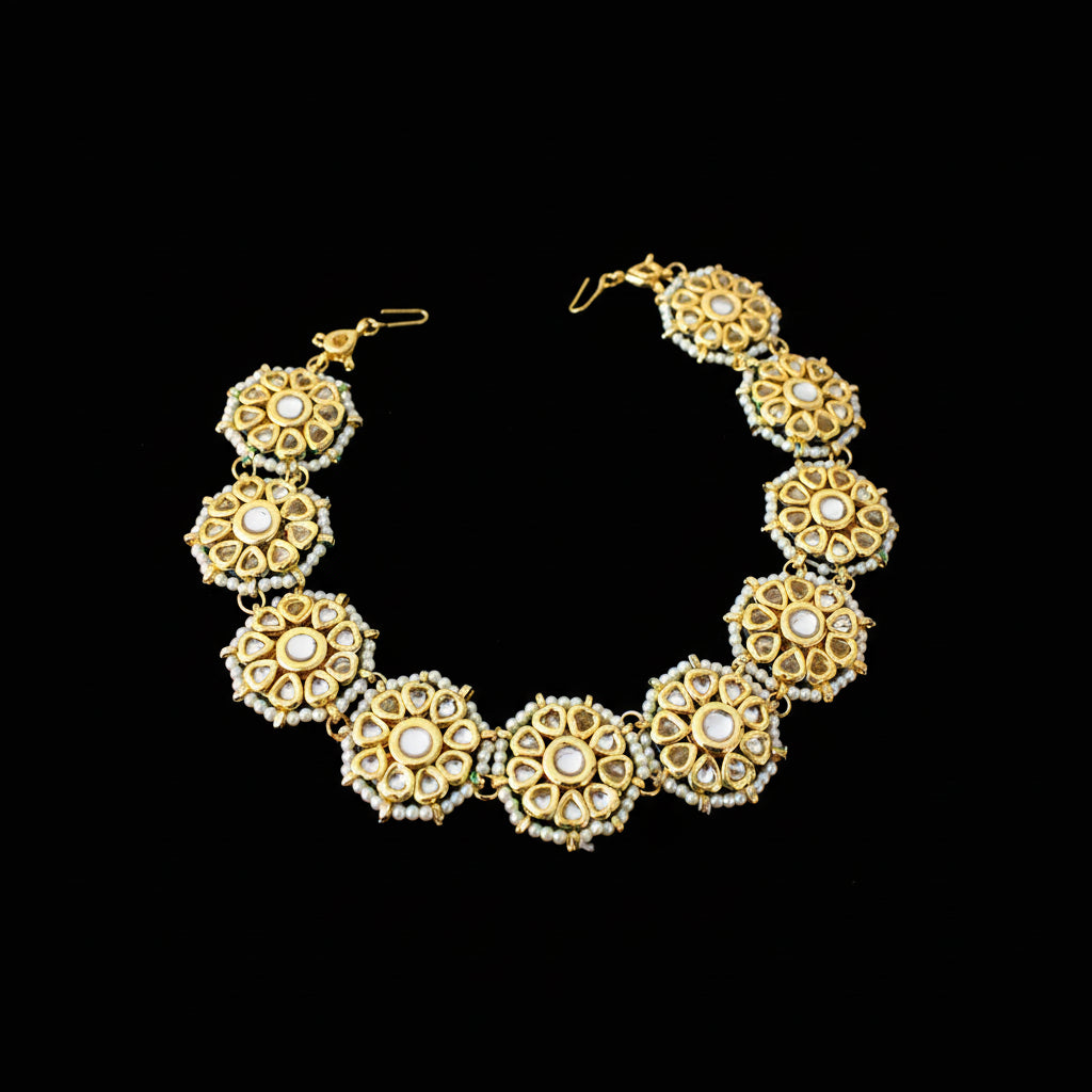 Gold and pearl necklace with matching earrings on a dark background, featuring the brand 'Saheli'.