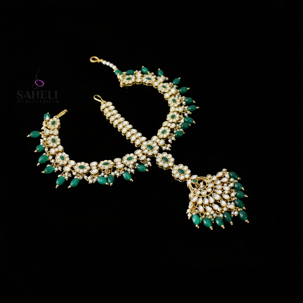 Jewelry set with necklace and bracelet featuring green stones on a dark background, branded 'Saheli'.