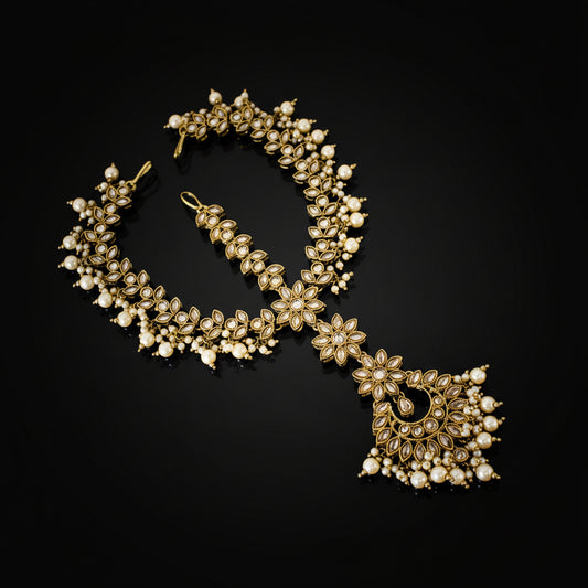Ornate necklace with floral design on a dark background, featuring the brand 'Saheli'.