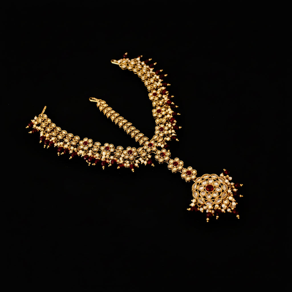 Ornate necklace with red stones on a dark background, featuring the brand 'Saheli'.