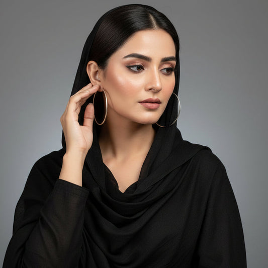 Silver hoop earrings on a dark gray background with 'Saheli' branding.