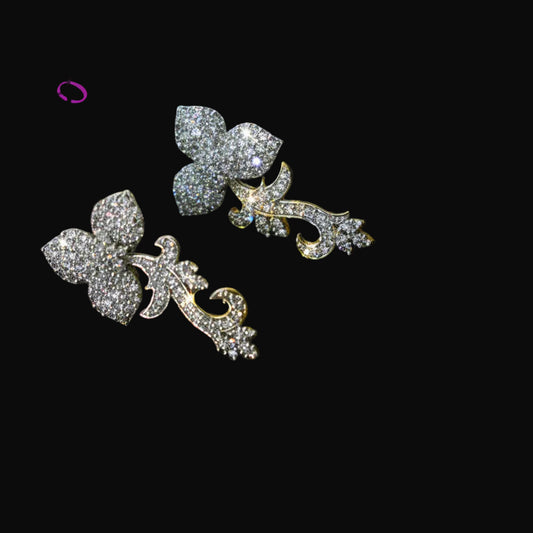 Pair of silver butterfly earrings with clear gemstones on a dark background, featuring the brand 'Saheli'.