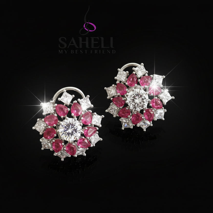 Pair of earrings with pink and white gemstones on a gray background, featuring the brand 'Saheli'.