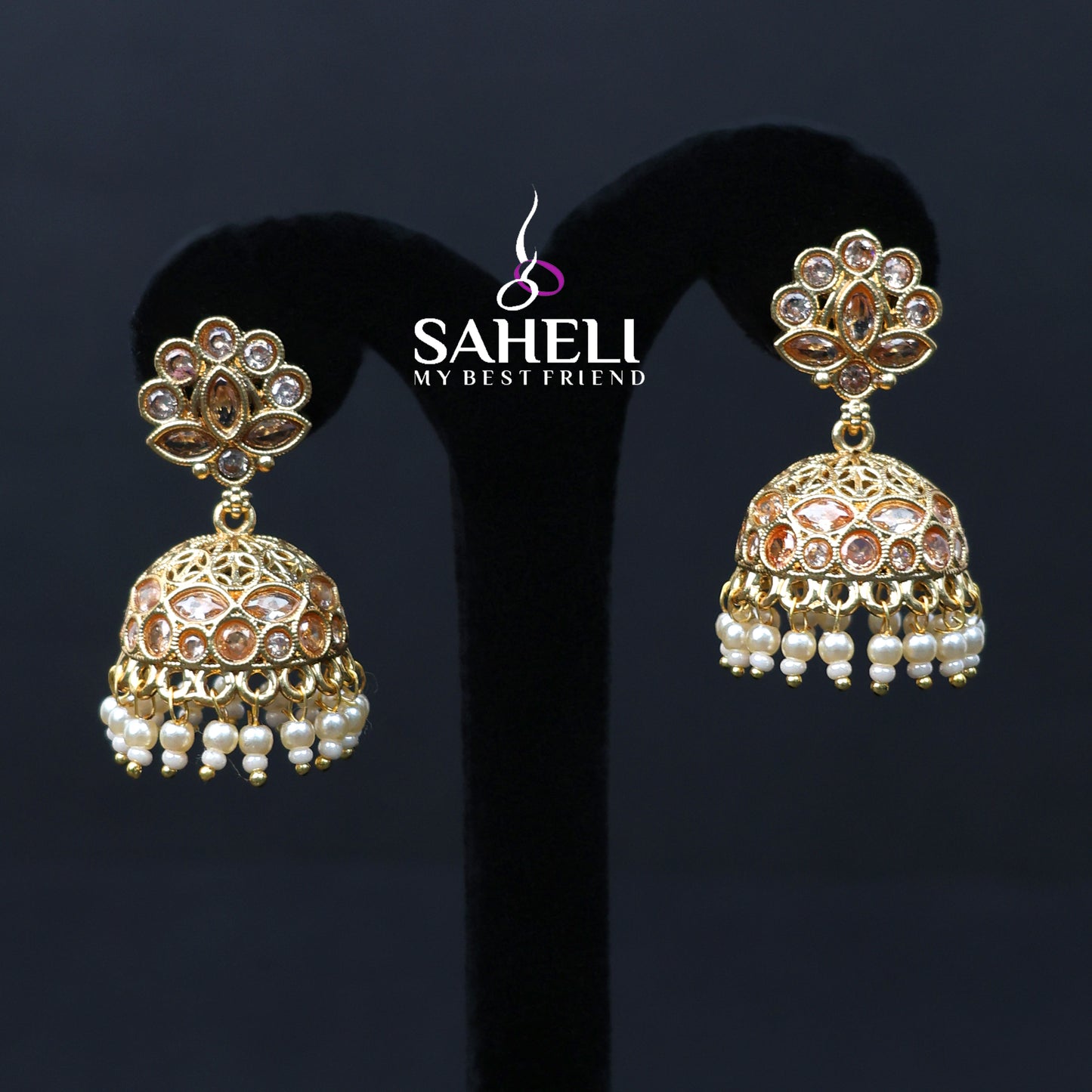 Gold and pearl earrings with 'SAHEL' brand logo on a dark background