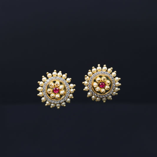 Pair of gold and pearl earrings on a black stand with 'SAHELII MY BEST FRIEND' branding.
