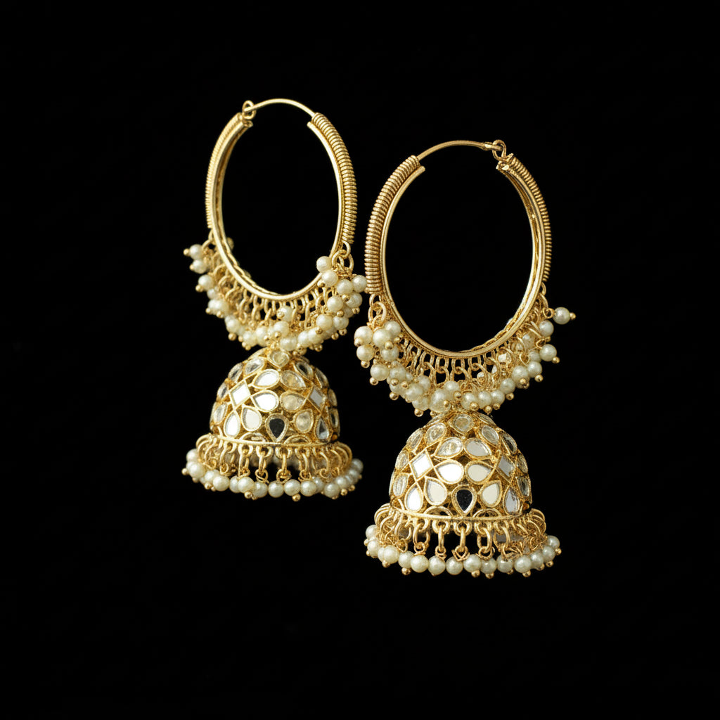 Pair of gold and pearl earrings on a black stand