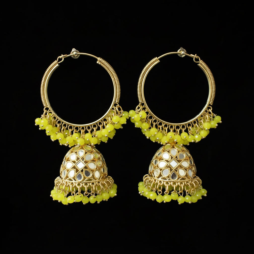 Gold and green earrings on black stands against a black background