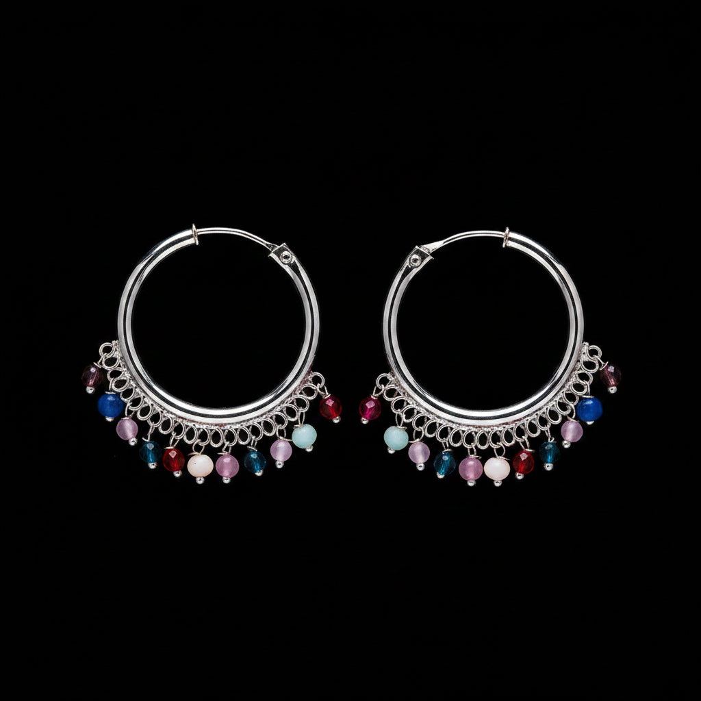 Pair of silver hoop earrings with colorful beads on a brown background