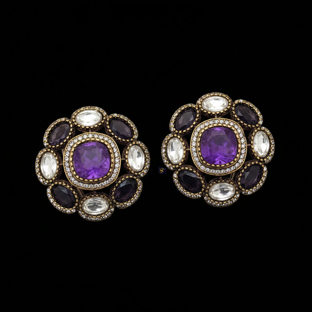 Pair of earrings with purple gemstones and decorative stones on a light gray background.