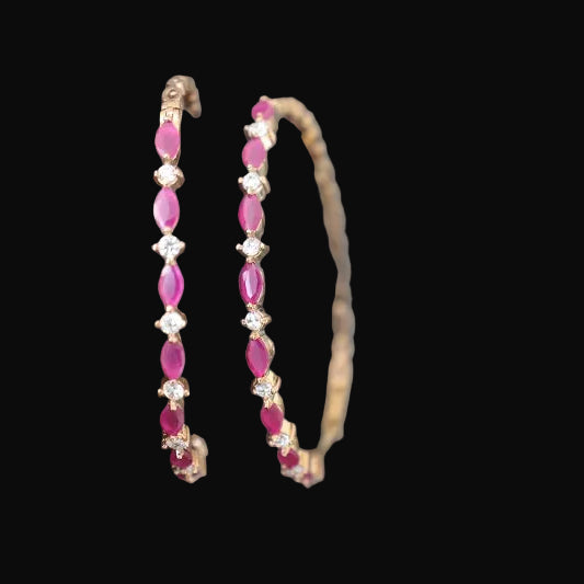 Pair of pink beaded bracelets on a gray stone surface with 'SAHELI' branding.