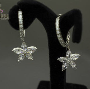 Butterfly-shaped earrings on a black stand with a gray background