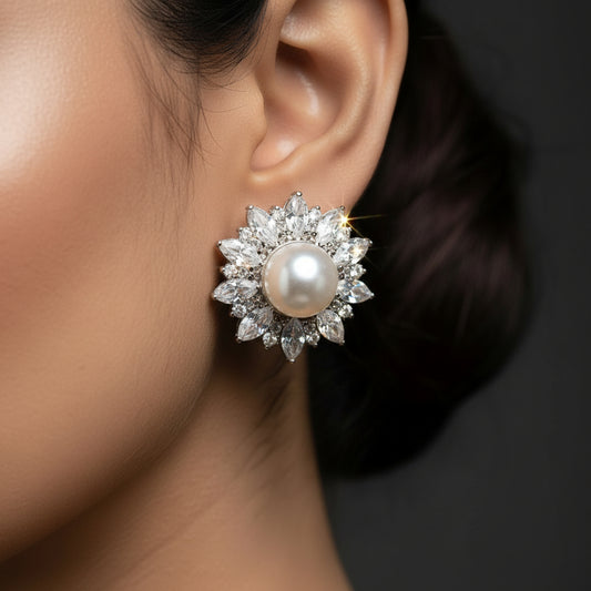 Pair of pearl earrings with silver floral designs on a black background